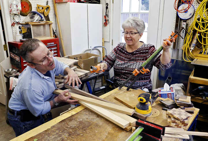 Jamie Hoy a woodworker who has cerebral palsy lays down some boards on his workshops table while his mom Connie Bullens lends a hand by preparing some clamps that will be used to glue the boards together to create a cutting board.   (Eric Albrecht / The Columbus Dispatch)